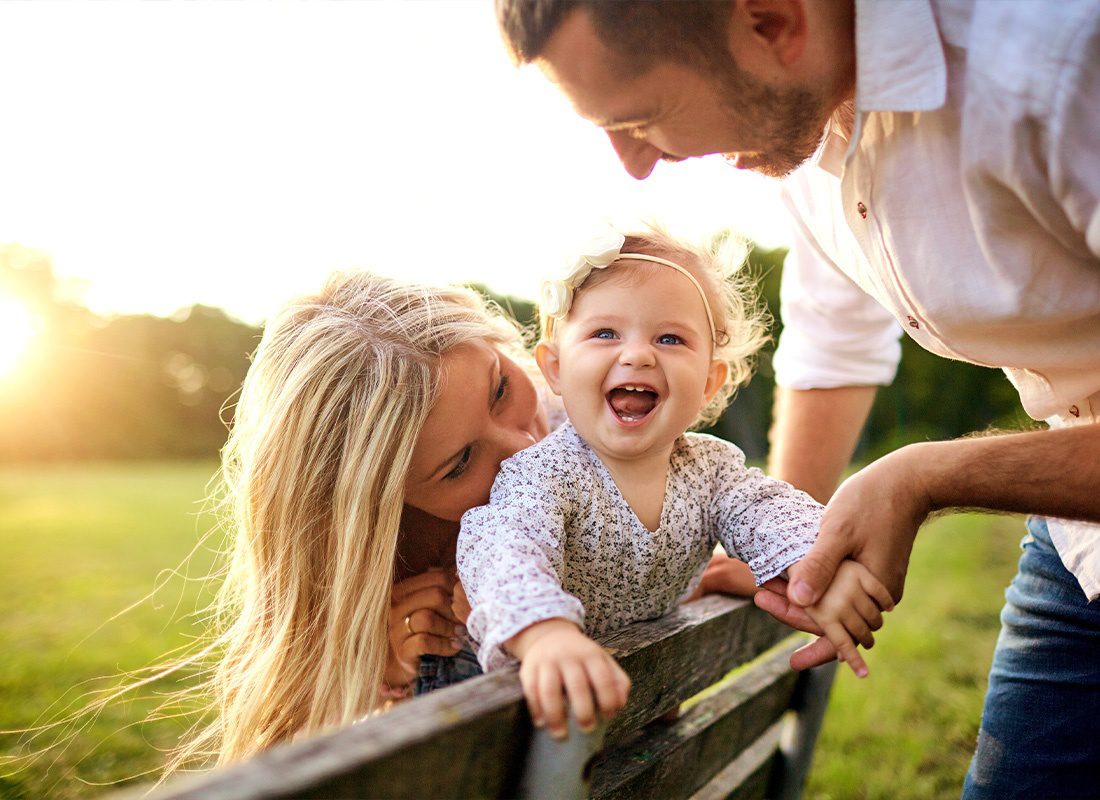 Insurance Solutions - Parents Spending Time With Their Daughter at a Park on a Sunny Day